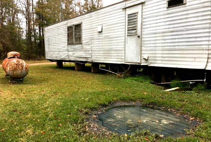 Raw sewage sits in an open-air pool outside a mobile home in a Butler County community where few residents have access to adequate sewage management services. (Connor Sheets | csheets@al.com)