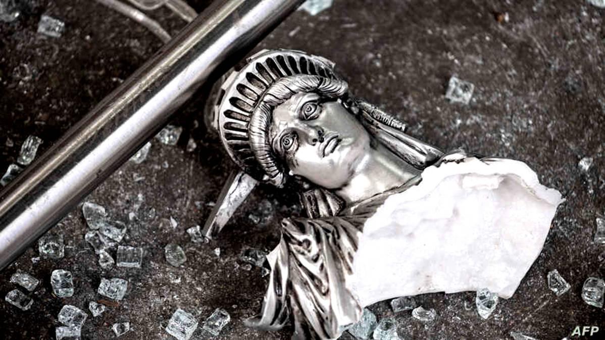 A broken Statue of Liberty figure is seen between glass shatters outside a looted souvenir shop after a night of protests over the death of African-American George Floyd in Minneapolis, in Manhattan in New York City, June 2, 2020. 