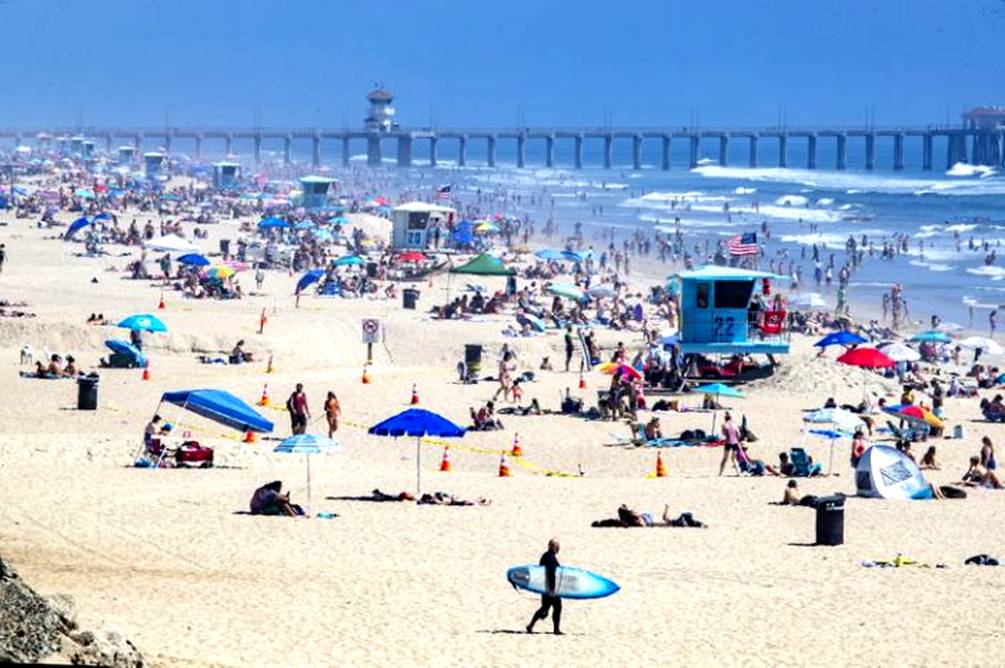 Thousands of beachgoers enjoy a warm, sunny day in Huntington Beach on April 25 amid state-mandated stay-at-home orders designed to stave off the coronavirus pandemic. <span class="copyright">(Allen J. Schaben / Los Angeles Times)</span>