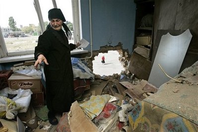 Venera Chebotaryova, 70, shows her destroyed apartment in Tskhinvali, ...