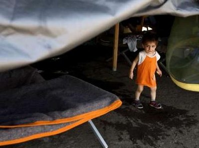 A child walks in a tent in a refugee camp for people displaced ...