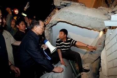 Chinese Premier Wen Jiabao  speaks to people buried at a ruined ...