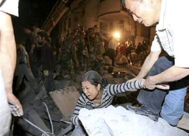 A rescuer tries to pull an injured woman out from the debris ...