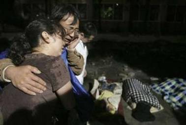 The parents of an earthquake victim mourn near their child&#39;s ...