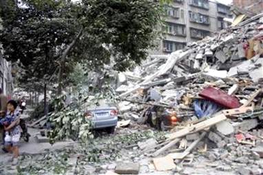 Cars are buried in the debris of collapsed buildings in Dujiangyan, ...