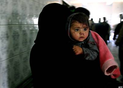 Иракская женщина в Бакубе бежит с раненым ребенком в больницу после нападения боевиков