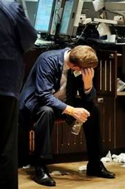 A specialist sits at his post on the floor of the New York Stock ...