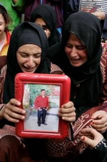A relative carries a photo of Faysal el-Abdallah who died a ...