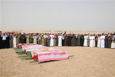 Syrian villagers pray over coffins during a mass funeral for ...