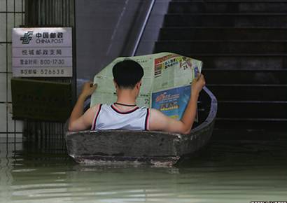 Молодой человек читает газету в лодке