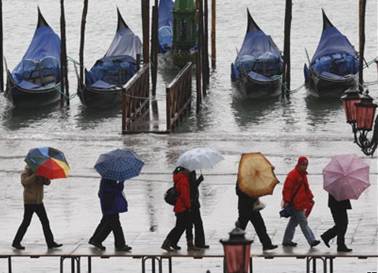 Люди под зонтами на деревянных мостках
