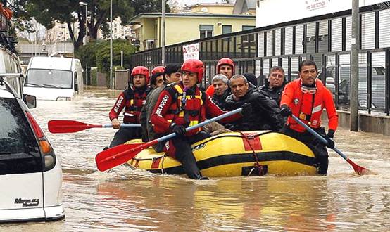Fire department rescuers ferry stranded people through flood waters near Via Tiburtina in Rome