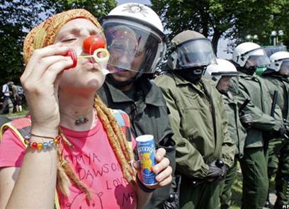 Участница манифестации в ходе саммита "Большой восьмерки" предлагает перековать полицейские дубинки на мыльные пузыри