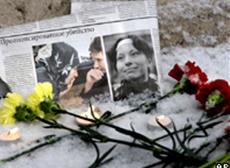 Газета с фотографиями убитых и цветы на месте преступления
