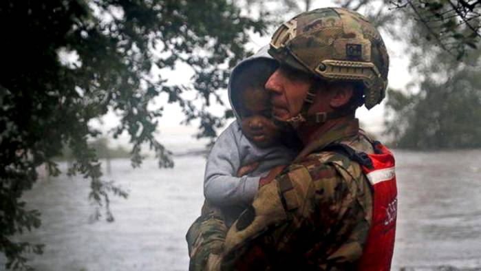 PHOTO: Rescue team member Sgt. Nick Muhar, from the North Carolina National Guard 1/120th battalion, evacuates a young child as the rising floodwaters from Hurricane Florence threatens his home in New Bern, N.C., on Friday, Sept. 14, 2018. (AP)