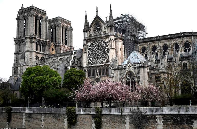 The catastrophic fire at Paris's Notre Dame Cathedral (shown this morning) has left a nation mourning the devastation of its cultural and historic 'epicentre' this morning as French President Emmanuel Macron vowed to rebuild the treasured landmark
