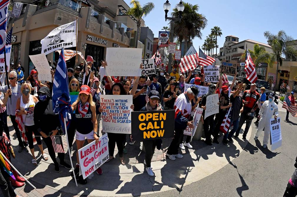 Protesters demonstrate against stay-at-home orders that were put in place due to the COVID-19 outbreak, Friday, April 17, 2020, in Huntington Beach, Calif.