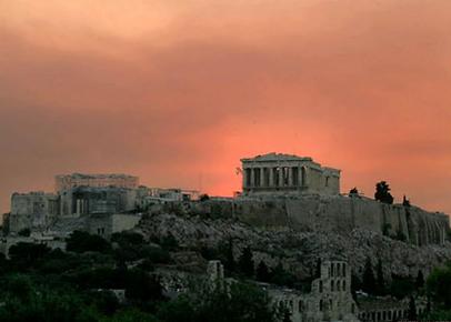 Массив Акрополя грустно возвышается над дымом от лесных пожаров в окрестностях греческой столицы Афин