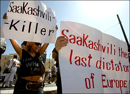 Противники президента Грузии Михаила Саакашвили показывают плакаты 'Саакашвили убийца' и 'Саакашвили последний диктатор в Европе' во время его визита в Грецию