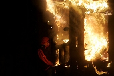 A rioter runs past the burning U.S. embassy in Belgrade, Serbia, ...