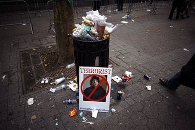 A discarded sign featuring a picture of Libyan leader Moammar ...